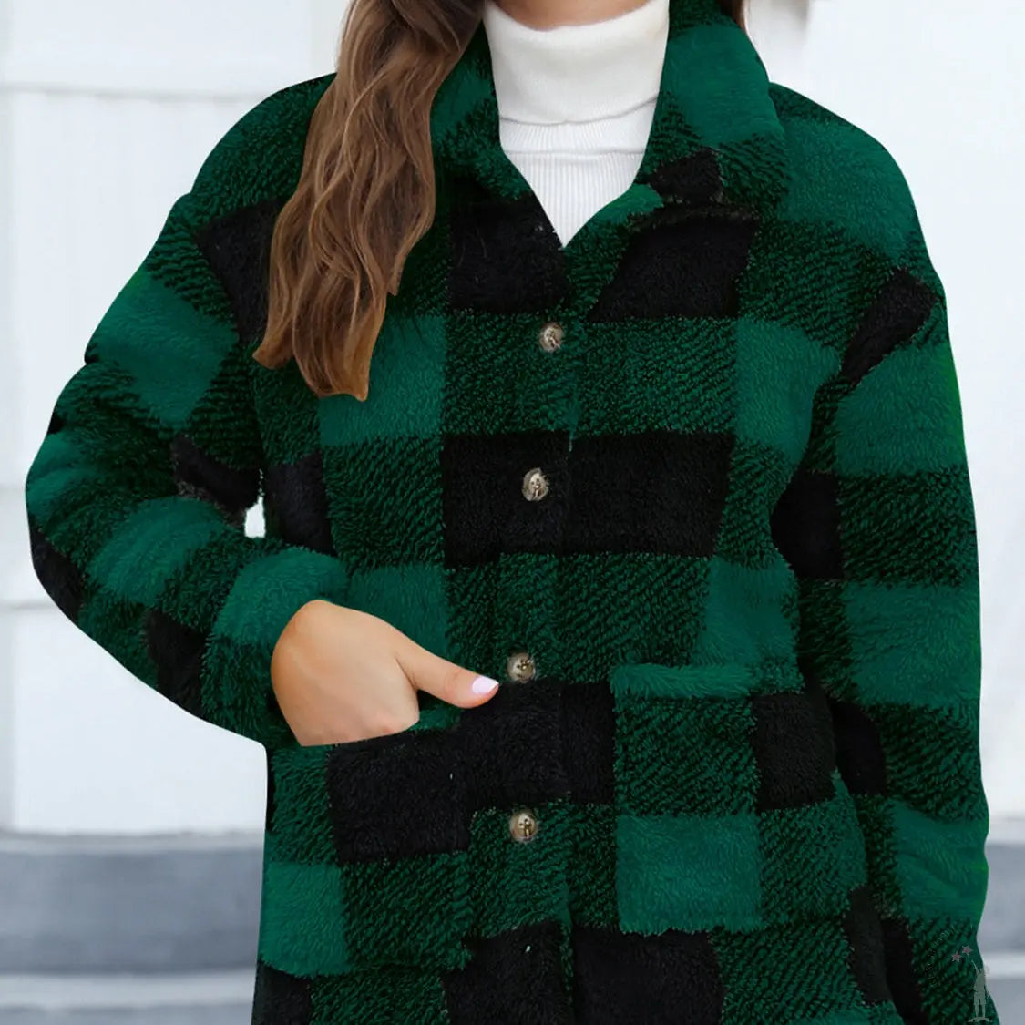 Person wearing a green and black checkered jacket with a white turtleneck and sunglasses.