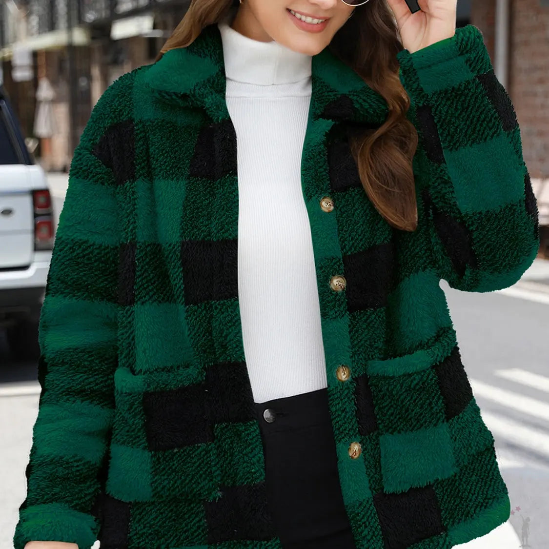 Woman wearing a green and black checkered jacket outdoors.