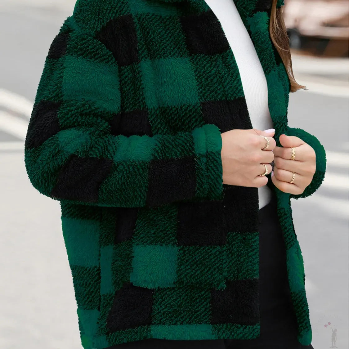 Green and black checkered coat worn by a lady with a blurred background