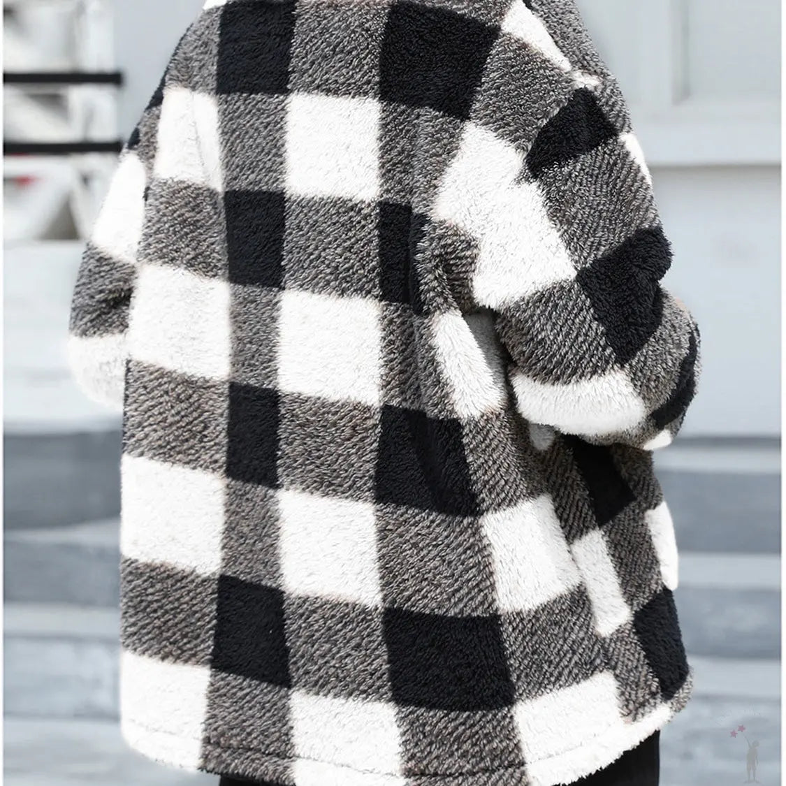 Person wearing a black and white checkered coat in an indoor setting - back view