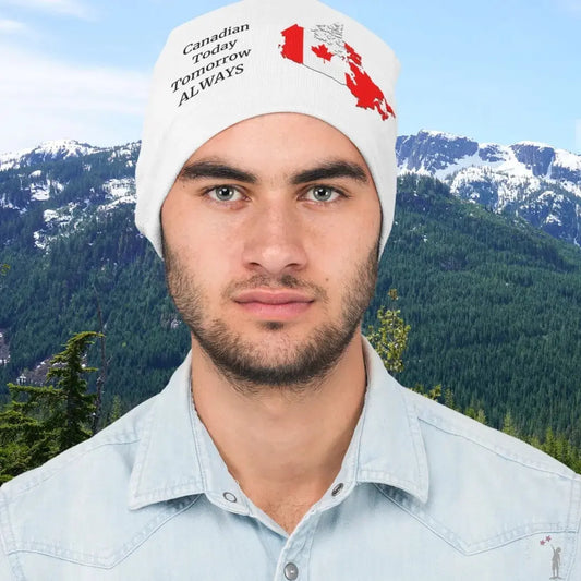 Man wearing a white beanie with text and a red maple leaf against a mountainous background