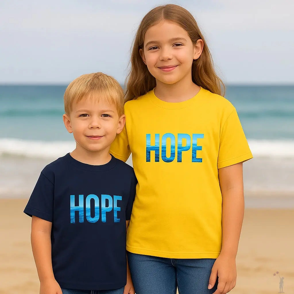 Two children wearing 'HOPE' t-shirts on a beach